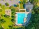 Aerial view of a community pool with ample seating, adjacent playground and parking, nestled in a lush green landscape at 135 Gaslight Blvd, Summerville, SC 29483