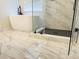 Bathroom featuring a soaking tub and a glass-enclosed shower with marble tile and sleek black hardware at 1350 Pinyon Pine Dr, Ladson, SC 29456