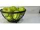 Close-up of a black wire basket filled with Granny Smith apples on a granite countertop at 1350 Pinyon Pine Dr, Ladson, SC 29456