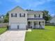 Charming two-story home with a well-manicured lawn, a covered front porch, and a two car garage at 1350 Pinyon Pine Dr, Ladson, SC 29456