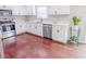 Well-lit kitchen with white cabinets, stainless steel appliances, and hardwood floors at 1350 Pinyon Pine Dr, Ladson, SC 29456