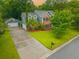 Aerial view of a two-story home with a detached garage, and long driveway surrounded by lush landscaping at 138 Shadowmoss Pkwy, Charleston, SC 29414