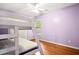 Bedroom with hardwood floors, bunk bed, light purple walls, and a window at 138 Shadowmoss Pkwy, Charleston, SC 29414