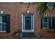 Charming front door with brick facade, a palm tree, and black shutters at 138 Shadowmoss Pkwy, Charleston, SC 29414