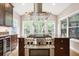 Well-equipped kitchen with a stainless steel range, custom hood, a wine fridge, and granite countertops at 138 Shadowmoss Pkwy, Charleston, SC 29414