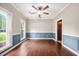 Sun-filled living room featuring fresh paint, wainscotting, hardwood flooring, and updated light fixture at 138 Shadowmoss Pkwy, Charleston, SC 29414