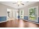 Bright living room with wainscotting, hardwood flooring, fresh paint, and large windows providing natural light at 138 Shadowmoss Pkwy, Charleston, SC 29414