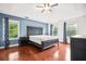 Spacious main bedroom with hardwood floors, large bed, ceiling fan and two windows at 138 Shadowmoss Pkwy, Charleston, SC 29414