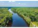 Overhead shot of dark river winding through lush green trees with a bright blue sky overhead at 150 Riverbend Ln, Ridgeville, SC 29472