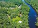 Aerial view showcases the extensive acreage, river frontage, multiple homes, and ponds on the property at 150 Riverbend Ln, Ridgeville, SC 29472