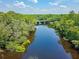 Aerial view of a tree-lined river with a bridge in the distance, showcasing the waterfront property's access at 150 Riverbend Ln, Ridgeville, SC 29472