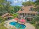 Charming home features a pool, an outdoor kitchen, a full porch, and lush landscaping at 150 Riverbend Ln, Ridgeville, SC 29472