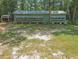 Exterior view of building with bee colony boxes, lush natural surroundings, and shaded area for honey harvesting at 150 Riverbend Ln, Ridgeville, SC 29472
