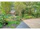 Front yard view of landscaped beds with flowers, trees and a decorative playhouse at 150 Riverbend Ln, Ridgeville, SC 29472
