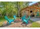 Inviting outdoor kitchen area with a fire pit and Adirondack chairs at 150 Riverbend Ln, Ridgeville, SC 29472