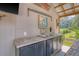 Outdoor kitchen area with a double sink, countertop, and wooden cabinets at 150 Riverbend Ln, Ridgeville, SC 29472