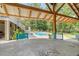 Outdoor pool view from covered patio featuring wood beams and plenty of natural light at 150 Riverbend Ln, Ridgeville, SC 29472