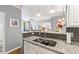 Kitchen view showcasing granite countertops, stainless steel sink, breakfast bar, and a view to the living room at 1600 Long Grove Dr # 1115, Mount Pleasant, SC 29464