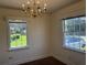 Bright dining room featuring a vintage chandelier, two windows, and wood flooring at 1674 Garden St, Charleston, SC 29407