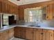 Traditional kitchen with wooden cabinets, stainless steel sink, and window view at 1674 Garden St, Charleston, SC 29407