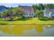 Aerial view of a home with a pond, lawn, and mature landscaping at 173 Silver Cypress Cir, Summerville, SC 29485