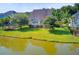 Aerial view of a house with a pond, lush lawn, and trees at 173 Silver Cypress Cir, Summerville, SC 29485