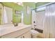 Bright bathroom with green walls features a white vanity, toilet, and shower/tub combo at 173 Silver Cypress Cir, Summerville, SC 29485