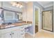 This bathroom features a granite countertop and makeup vanity next to a walk-in shower and a walk-in closet at 173 Silver Cypress Cir, Summerville, SC 29485