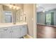 This bathroom features a sink with a mirror over a white vanity and an open door leading into the bedroom at 173 Silver Cypress Cir, Summerville, SC 29485