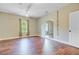 Bright bedroom with hardwood floors, ceiling fan, window, and an oversized full length mirror at 173 Silver Cypress Cir, Summerville, SC 29485