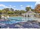 Inviting community pool area featuring lounge chairs, clear blue water, and a charming covered pavilion for relaxation at 173 Silver Cypress Cir, Summerville, SC 29485