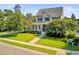 Attractive two-story house featuring a verdant lawn, flowering trees, and a paved walkway at 173 Silver Cypress Cir, Summerville, SC 29485