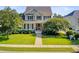 Beautiful two-story home with a lush green lawn, mature trees, and a sidewalk leading to the entrance at 173 Silver Cypress Cir, Summerville, SC 29485