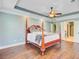 This spacious main bedroom features a four-poster bed, a ceiling fan, and an entrance into the bathroom at 173 Silver Cypress Cir, Summerville, SC 29485
