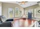 Bright sunroom with large windows, wood floors, and a cozy seating area at 173 Silver Cypress Cir, Summerville, SC 29485