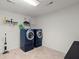 Well-lit laundry room featuring two large blue washing machines with storage shelves, providing convenience and organization at 190 Darcy Ave, Goose Creek, SC 29445
