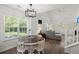 Bright living room with a dining area, large windows, hardwood floors, and a modern light fixture at 190 Darcy Ave, Goose Creek, SC 29445