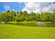 Picturesque pond with a water fountain surrounded by vibrant green grass and lush trees at 190 Darcy Ave, Goose Creek, SC 29445
