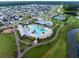 Aerial view of homes in a community, swimming pool, clubhouse, and pond with green trees at 203 Symphony Ave, Summerville, SC 29486