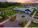 Aerial view of a clubhouse with pond, recreational area, and parking lot surrounded by community homes at 203 Symphony Ave, Summerville, SC 29486