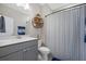 Stylish bathroom with modern vanity, mirror, shelving, and shower with elegant striped curtain at 203 Symphony Ave, Summerville, SC 29486