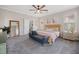 Sunlit bedroom featuring a bed, blue bench, decor mirror, and carpeted floors at 203 Symphony Ave, Summerville, SC 29486