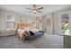 Bright bedroom with a large bed, ceiling fan, bench, and carpeted floor at 203 Symphony Ave, Summerville, SC 29486