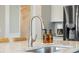 Close-up of kitchen sink with stainless steel faucet and soap dispensers, with view of granite countertop at 203 Symphony Ave, Summerville, SC 29486