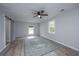 Bedroom with ceiling fan, wood-look floors, neutral walls, windows, and a modern sliding barn door at 204 Foxborough Rd, Goose Creek, SC 29445