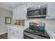 Close up of a stainless steel microwave and range showcasing white countertops in the updated kitchen at 204 Foxborough Rd, Goose Creek, SC 29445