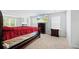 Spacious bedroom featuring a large bed with red sheets, TV, and two windows for natural lighting at 217 Black Tupelo Ct, Moncks Corner, SC 29461