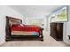 Spacious bedroom featuring a large bed with red sheets, TV, and two windows for natural lighting at 217 Black Tupelo Ct, Moncks Corner, SC 29461