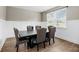 Dining room with tufted chairs, wainscoting, large window and wood flooring at 217 Black Tupelo Ct, Moncks Corner, SC 29461