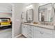 Modern bathroom features dual sinks with white cabinets and a view to the bedroom at 2226 Arthur Rose Ln, Johns Island, SC 29455